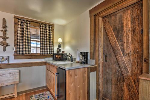 a kitchen with a sink and a wooden door at Berkeley Springs Haven with Sleepy Creek Access! in Berkeley Springs