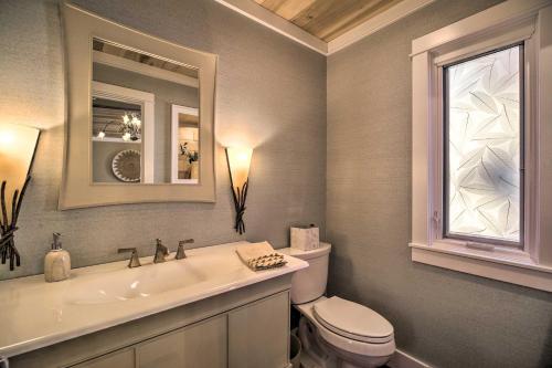 a bathroom with a toilet and a sink and a mirror at Waterfront Home on Norris Lake with Boat Slip! in La Follette