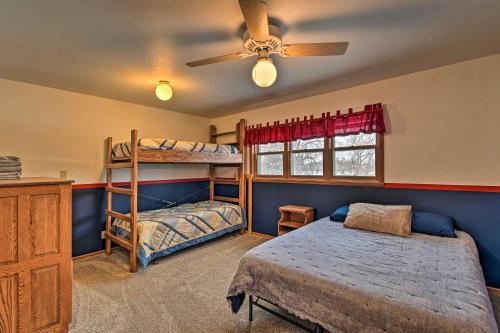 a bedroom with two bunk beds and a ceiling fan at Waterfront Fond du Lac Home on DeNeveu Lake! in Fond du Lac