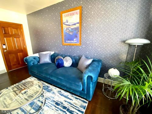 a blue couch in a living room with a wall at Bright OKC Midtown Studio-Coolest neighborhood in Oklahoma City