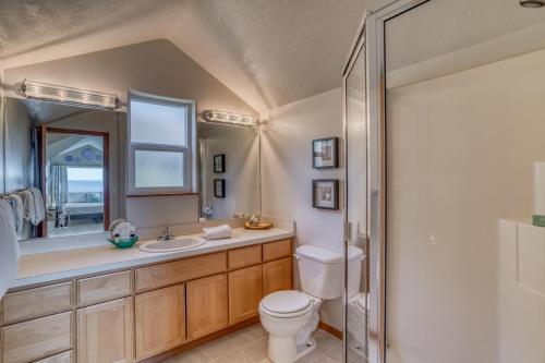 a bathroom with a toilet and a sink and a shower at Hubbert Hideaway in Lincoln City