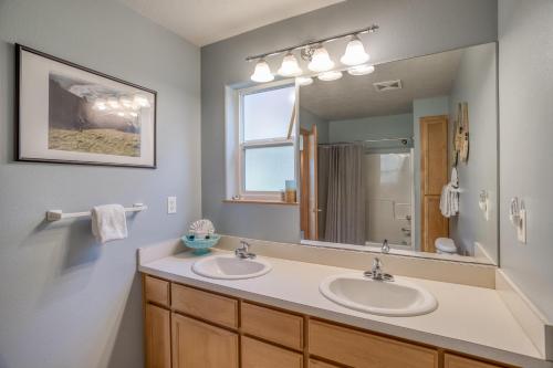 a bathroom with two sinks and a large mirror at Hubbert Hideaway in Lincoln City