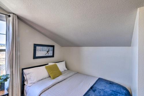 a small bedroom with a bed with a yellow pillow at 503 Mountain Loft with Views 1 Mi to Dwtn Fairplay! in Fairplay