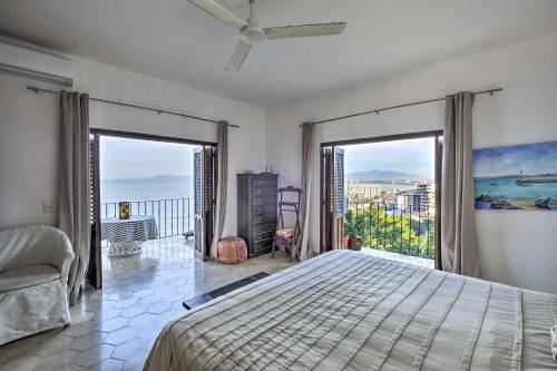 プエルト・バジャルタにあるMid-Century Modern Condo with Patio and Ocean Views!のベッドと2つの大きな窓がある寝室