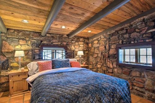 a bedroom with a bed in a stone wall at Luxury Log Cabin Less Than 15 Mi to Downtown Moab! in Moab