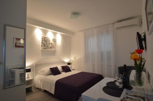 a bedroom with a bed and a desk and a window at Downtown Main Street Studio in Zadar