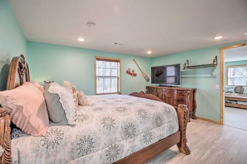 a bedroom with a bed and a flat screen tv at Outdoor Family Fun Large Home by Beaver Lake! in Eureka Springs
