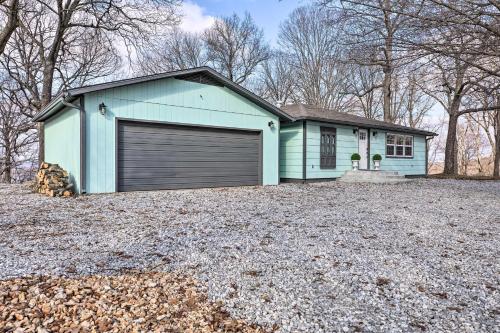a blue house with a garage in a yard at Outdoor Family Fun Large Home by Beaver Lake! in Eureka Springs