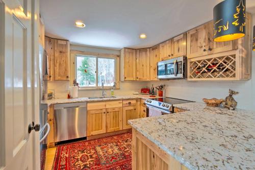 a kitchen with wooden cabinets and a granite counter top at Spacious Village of Loon Home Less Than 1 Mi to Ski Slopes in Lincoln