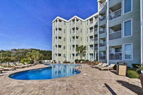 a large apartment building with a swimming pool and chairs at Oceanfront Myrtle Beach Condo with Resort Perks! in Myrtle Beach