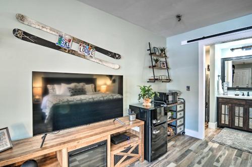 a living room with a large television and a bed at Ski-InandSki-Out Getaway at Boyne Mountain Resort in Boyne Falls