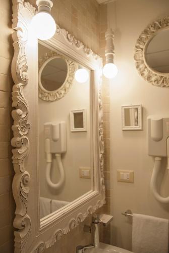 a bathroom with a large mirror and a sink at Hotel Acquamarina in Donnalucata