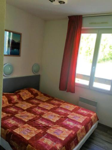 - une chambre avec une couette sur un lit et une fenêtre dans l'établissement Skis aux pieds station 1600 Sun Vallée, à Puy-Saint-Vincent