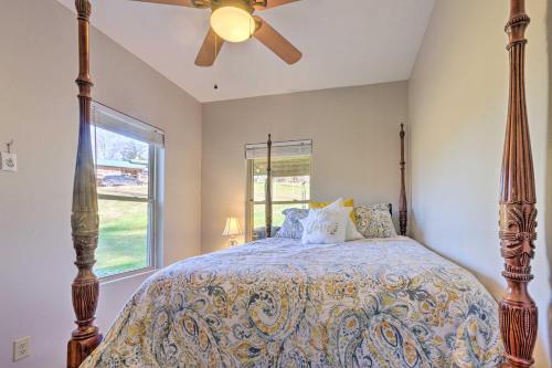 a bedroom with a bed with a ceiling fan and a window at Cherokee Natl Forest Retreat Renovated Cabin! in Greeneville