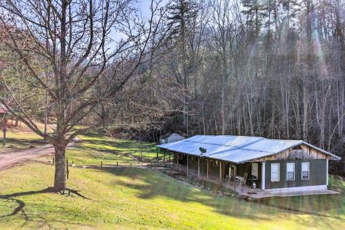 a small house with a blue roof in a field at Cherokee Natl Forest Retreat Renovated Cabin! in Greeneville
