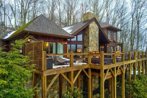 a log home with a large wooden deck at Luxe Beech Mtn Cabin with Hot Tub 2 Mi to Skiing! in Beech Mountain