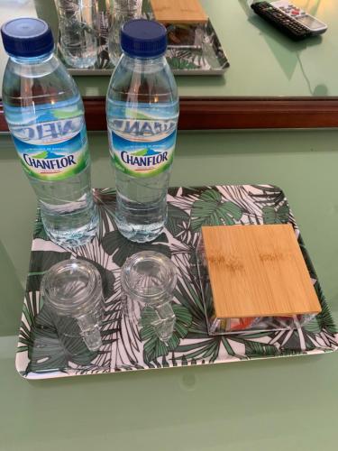 a tray with two bottles of water on a table at Studio Green Jungle in La Trinité