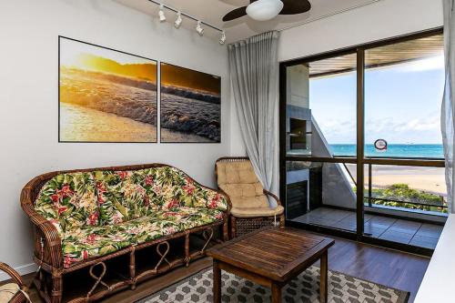 a living room with a couch and a table at Apto com vista panorâmica de frente p/ mar POR204 in Florianópolis