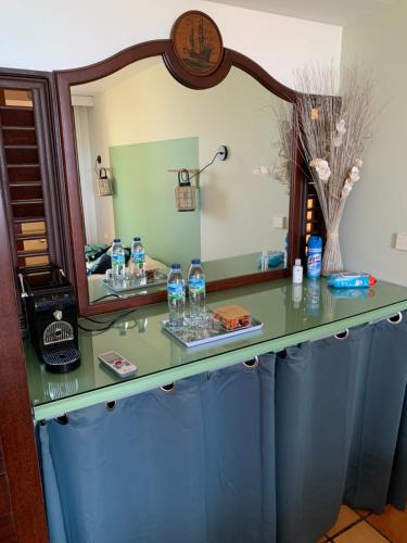 a dressing table with a mirror and bottles on it at Studio Green Jungle in La Trinité