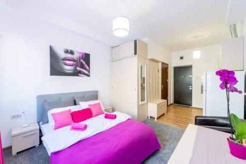 um quarto com uma cama grande e almofadas cor-de-rosa em Apartament Cristian em Arad