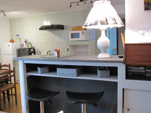 a kitchen with a counter with stools and a lamp at LOUCABANON VAR in Draguignan