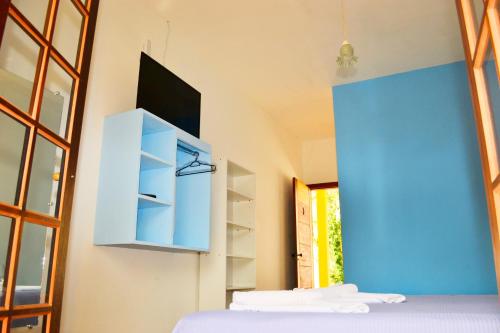 Cette chambre comprend un lit et un mur bleu. dans l'établissement Pouso Paratiense Jabaquara, à Parati