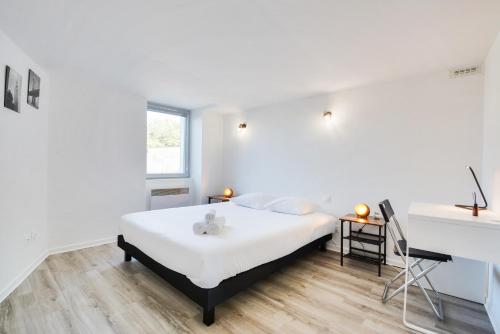 une chambre blanche avec un lit et une fenêtre dans l'établissement Les Cosy De Nancy La tanière de la porte verte 4étoiles, à Nancy