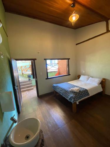 a bedroom with a bed and a sink and a bathroom at Pousada Lapralapa in Santana do Riacho
