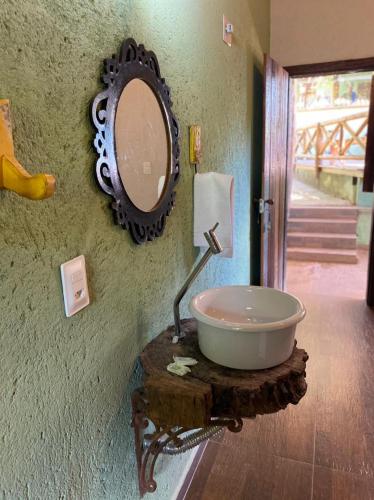 a bathroom with a sink and a mirror on a wall at Pousada Lapralapa in Santana do Riacho