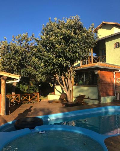 a swimming pool in front of a house at Pousada Lapralapa in Santana do Riacho