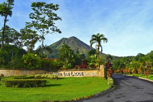 a road with a sign with a mountain in the background at Los Lagos Spa & Thermal Resort Experience in Fortuna