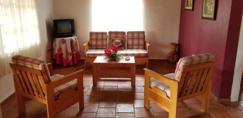 a living room with two chairs and a table and a couch at Cabañas Bosque llano de la Virgen in Intibucá