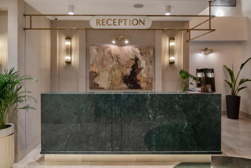 a reception desk in a lobby with a painting at Delita City Hotel in Istanbul