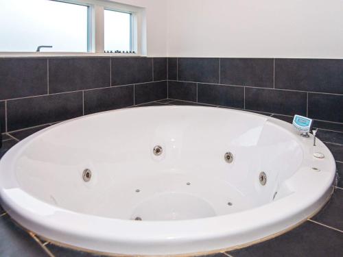 eine große weiße Badewanne im Bad mit Fenster in der Unterkunft 14 person holiday home in Glesborg in Glesborg
