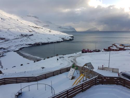 a view of a snow covered hill with a ski slope at Stykkjastova - view and positioning in Kvívík