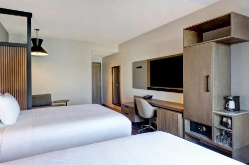 a hotel room with two beds and a desk at Hyatt Place Prince George in Prince George