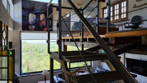 eine Wendeltreppe in einem Zimmer mit Fenster in der Unterkunft Casa en las Sierras de Córdoba in Unquillo