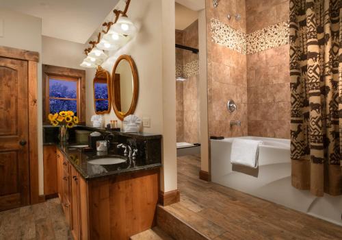 La salle de bains est pourvue d'une baignoire, d'un lavabo et d'une douche. dans l'établissement Parkway Inn of Jackson Hole, à Jackson