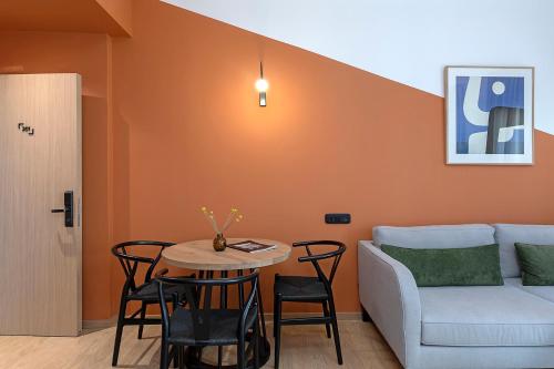 a living room with a couch and a table and chairs at Acro Urban Suites in Athens