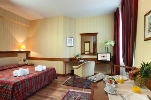 a hotel room with a bed and a desk at Hotel Lombardia in Milan