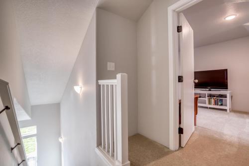 a hallway with white walls and a staircase with a television at Valhalla Vista - Meredith Lodging in Neskowin