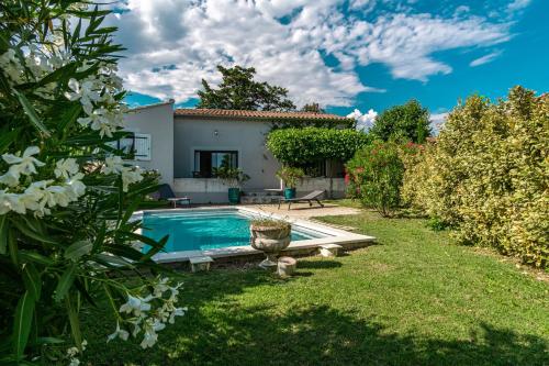 a garden with a swimming pool and a house at La Verdière - Contemporary house with garden and private pool in LʼIsle-sur-la-Sorgue