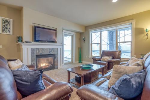 a living room with leather furniture and a fireplace at Herons View at Bridgeport - Meredith Lodging in Seaside