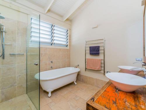 a bathroom with a tub and a shower and a sink at SeaCrest in Yamba