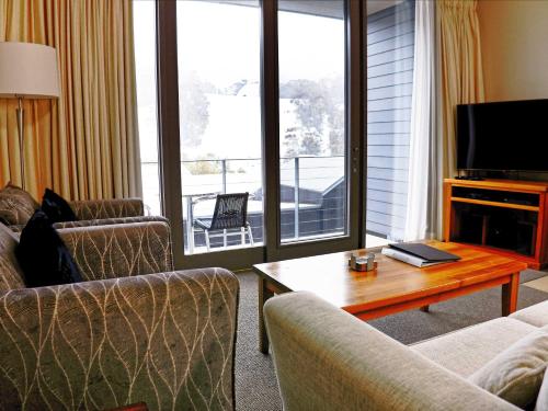 a living room with a couch and a table at Squatters Run Apartments in Thredbo