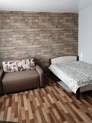 ein Schlafzimmer mit einem Bett und einem Sofa in der Unterkunft Apartment Комфорт для Вас in Krasnojarsk