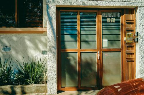 a wooden door to a building with plants in front at Saint Martin Apartments in Guadalajara