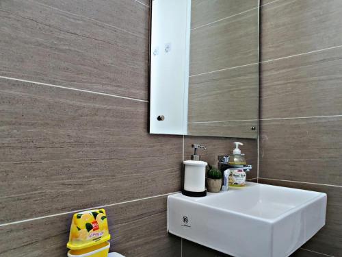 a bathroom with a white sink and a mirror at 【The Unique Home◆】Brand New Condo in Setapak KL in Kuala Lumpur