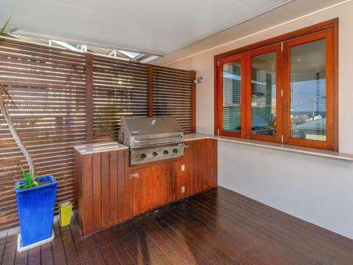 a kitchen with a stove and some windows at Seagrass House in Yamba