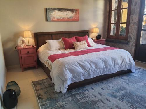 a bedroom with a large bed with red pillows at Mansion San Miguel in San Miguel de Allende